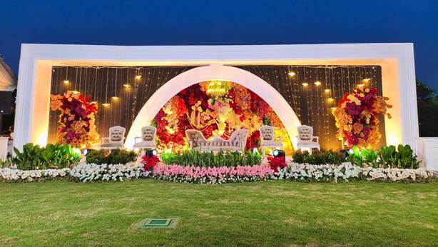 An outdoor event setup with a floral arch and seating. - Amalia Hotel Lampung (Bandar Lampung)