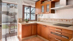 Une cuisine avec des meubles de rangement en bois, un évier et une fenêtre.