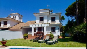 Un bâtiment à deux étages doté d’une piscine, d’un espace extérieur aménagé et d’un jardin.