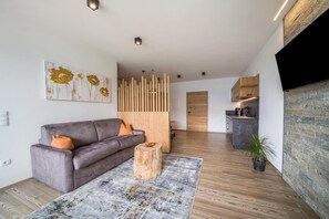 A modern living room with a sofa, a coffee table, and a decorative wall piece.