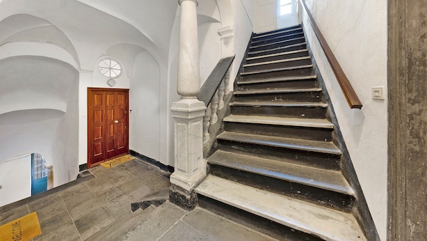 A grand staircase with a wooden handrail, white columns, and a wooden door at the top. - Holiday Apartment "Giomar" (levanto)