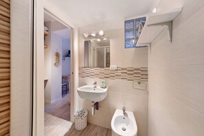 Un baño con lavabo, bidé y espejo.