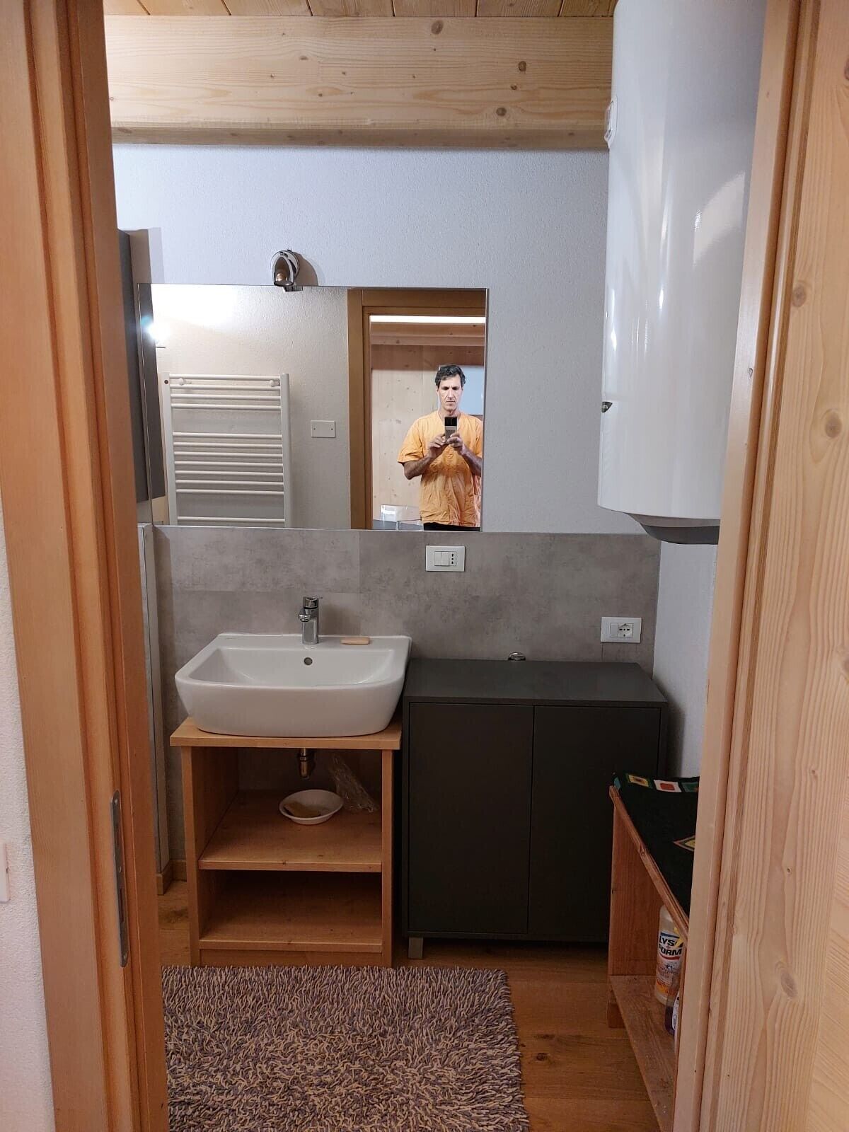A compact bathroom with a sink, mirror, and cabinets.