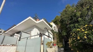 A house with a stone facade, a small porch, and a staircase leading up to the entrance. - Lovely flat near the beach, terrace AV-04 (Roses)