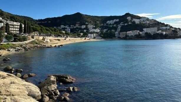 A coastal town with buildings on a hillside, a beach, and rocky shoreline. - Lovely flat near the beach, terrace AV-04 (Roses)