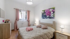 Ein Schlafzimmer mit Bett, Nachttisch, Lampe und einem Bild an der Wand.