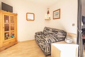 A living room with a sofa, a wooden cabinet, and a small table.