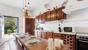 Une cuisine avec des meubles en bois, un four encastré et un grand îlot central agrémenté de bougies.