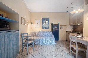 A compact kitchen with a sofa, a dining table, and a microwave. - Apartment 'Ca Lindaria' with Balcony, Wi-Fi and Air Conditioning (Bonassola)