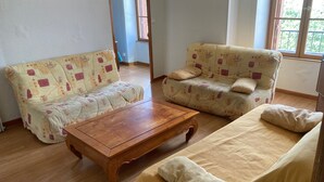 Una sala de estar con dos sofás, una mesa de centro y un ventanal con vistas.