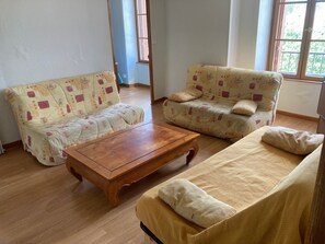 Una sala de estar con dos sofás, una mesa de centro y un ventanal con vistas.
