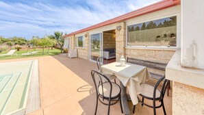 A patio with a table and chairs, a pool, and a view of the surrounding landscape. - Apartment 'Dependance Con Piscina' with Private Pool, Wi-Fi and Air Conditioning (taurisano)