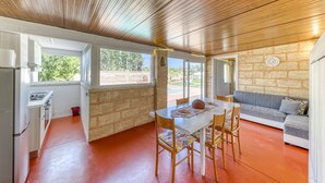 A kitchen with a dining area, a stone wall, and a view of the outdoors. - Apartment 'Dependance Con Piscina' with Private Pool, Wi-Fi and Air Conditioning (taurisano)