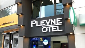 Entrada de un hotel con un cartel que dice "PLEVNE OTEL".