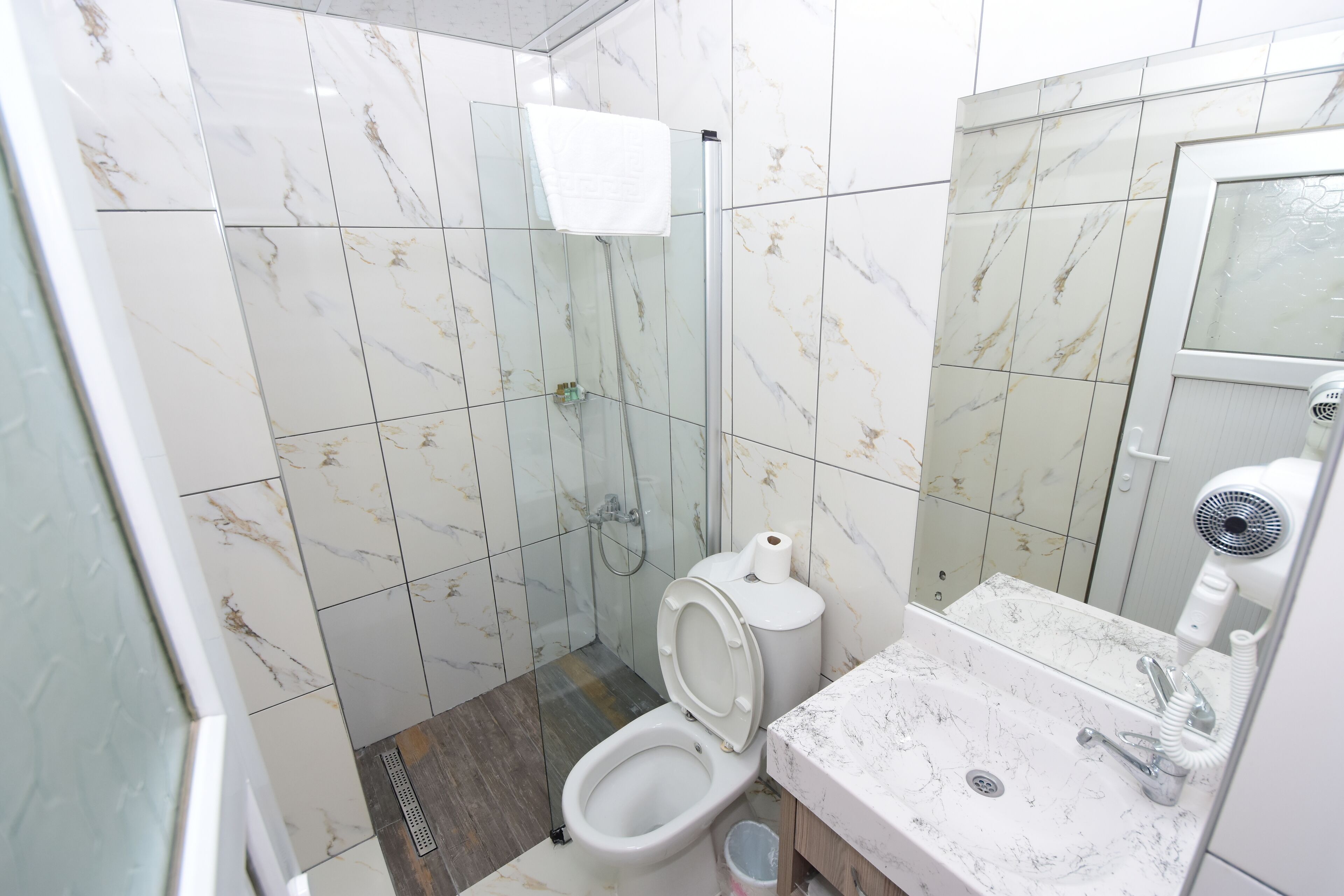Un baño con inodoro, ducha y lavamanos.
