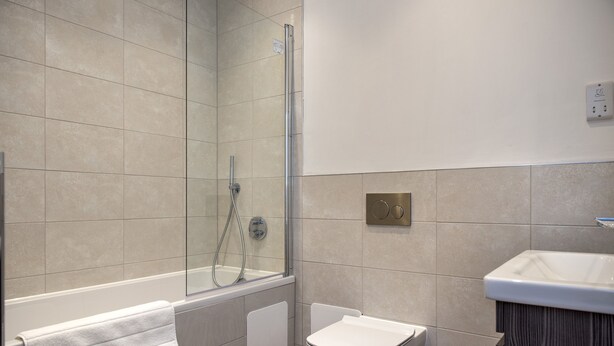 Une salle de bain moderne avec une douche à parois de verre, des toilettes et un lavabo.