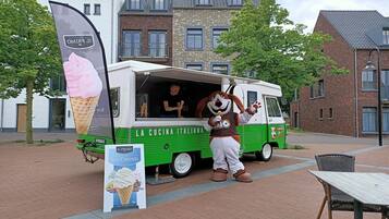 A food truck with a person in a dog costume standing next to it.