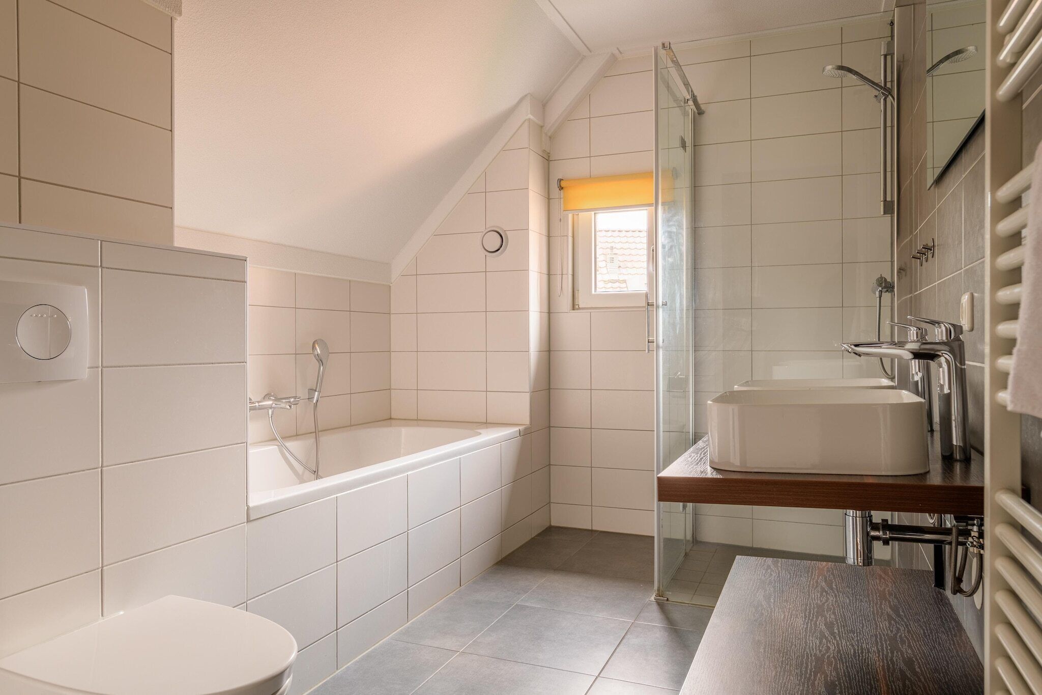 A modern bathroom with a bathtub, a toilet, and a sink.