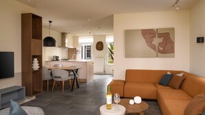 Una sala de estar moderna con un sofá, una mesa de centro y un comedor con sillas.