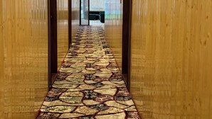 A hallway with a patterned carpet and wooden walls. - The Heritage Safina Group Of Houseboats (Srinagar)