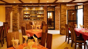 Un restaurante con paredes de ladrillo, vigas de madera y mesas dispuestas para comer.