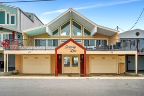 A two-story building with a prominent balcony and a sign that reads "Serenity at the Lake".