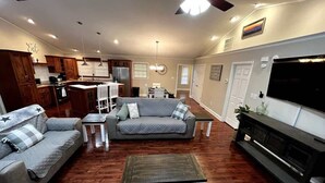 A spacious living room with a sofa, two armchairs, a coffee table, and a TV. - KunTree Retreat by Beyond Expectations: Pet-Friendly w/ Hot Tub, Sauna & Firepit (Sevierville)