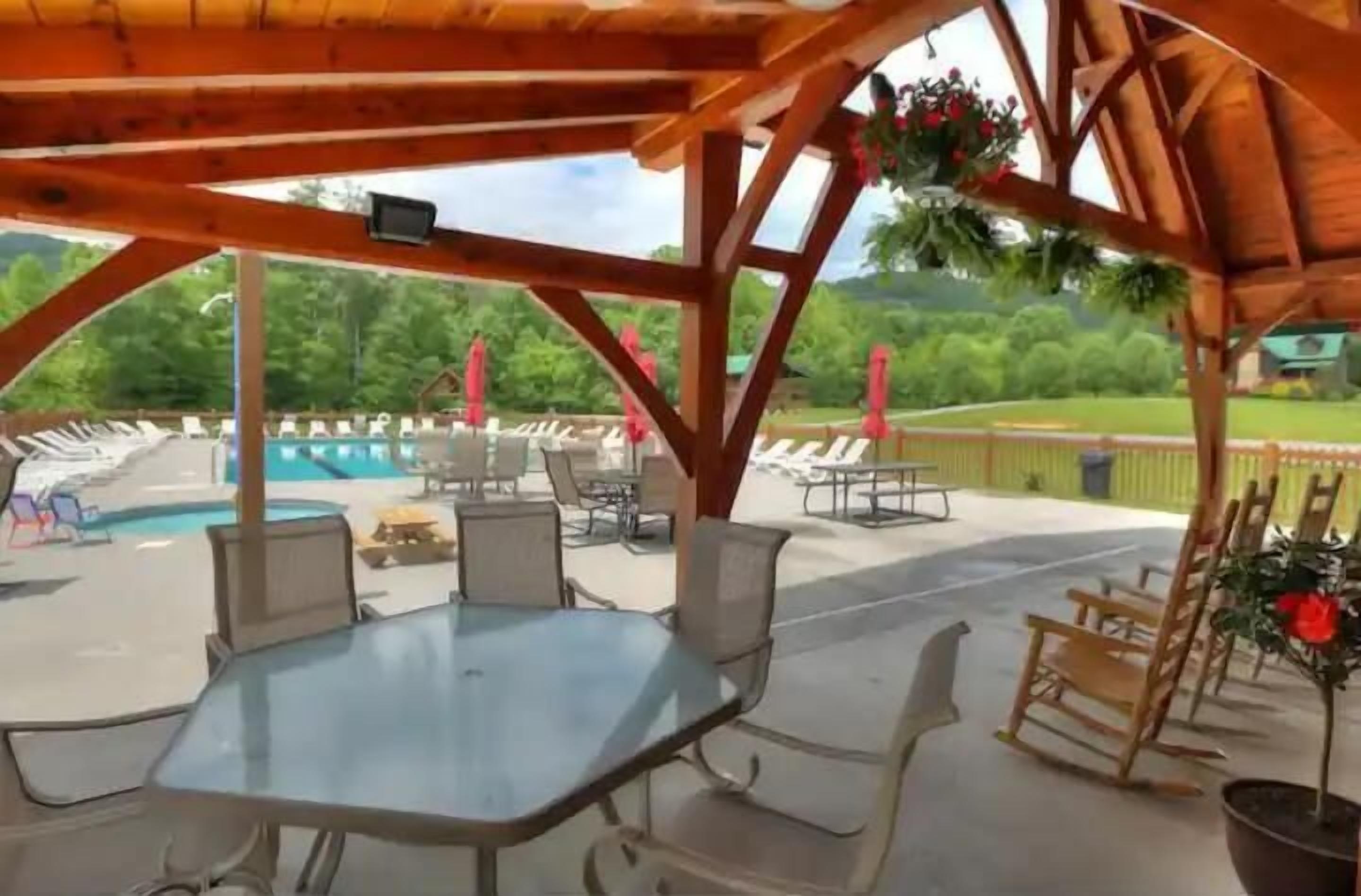 Une terrasse extérieure avec une piscine, des chaises longues et une table.