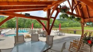 An outdoor patio with a pool, lounge chairs, and a table. - KunTree Retreat by Beyond Expectations: Pet-Friendly w/ Hot Tub, Sauna & Firepit (Sevierville)
