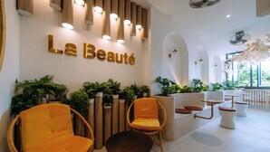 A spa area with a reception desk, seating, and plants. - La Beaute Hotel Quy Nhon (Quy Nhon)