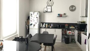 Una cocina moderna con comedor, que incluye un refrigerador, microondas y diversos electrodomésticos.