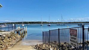 A marina with boats, a dock, and a caution sign warning of a slippery ramp.