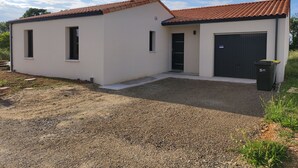 A modern single-story house with a tiled roof, a garage, and a gravel driveway. - Villa a Angles (Angles)