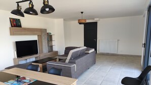 A modern living room with a TV, sofa, and dining area. - Villa a Angles (Angles)