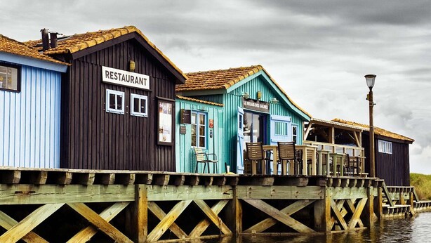 Een houten steiger met een restaurant en een café.