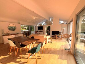 A modern interior with a dining area, seating, and a fireplace.