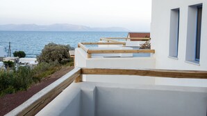 Un bâtiment moderne doté d’une terrasse en bois qui donne sur une étendue d’eau.