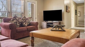 A living room with a sofa, coffee table, and television.