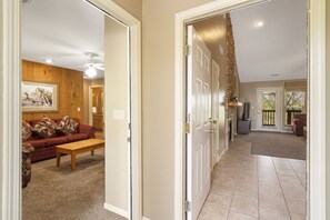 Enter a spacious hallway leading to a living and dining area with a high ceiling and natural ambiance.