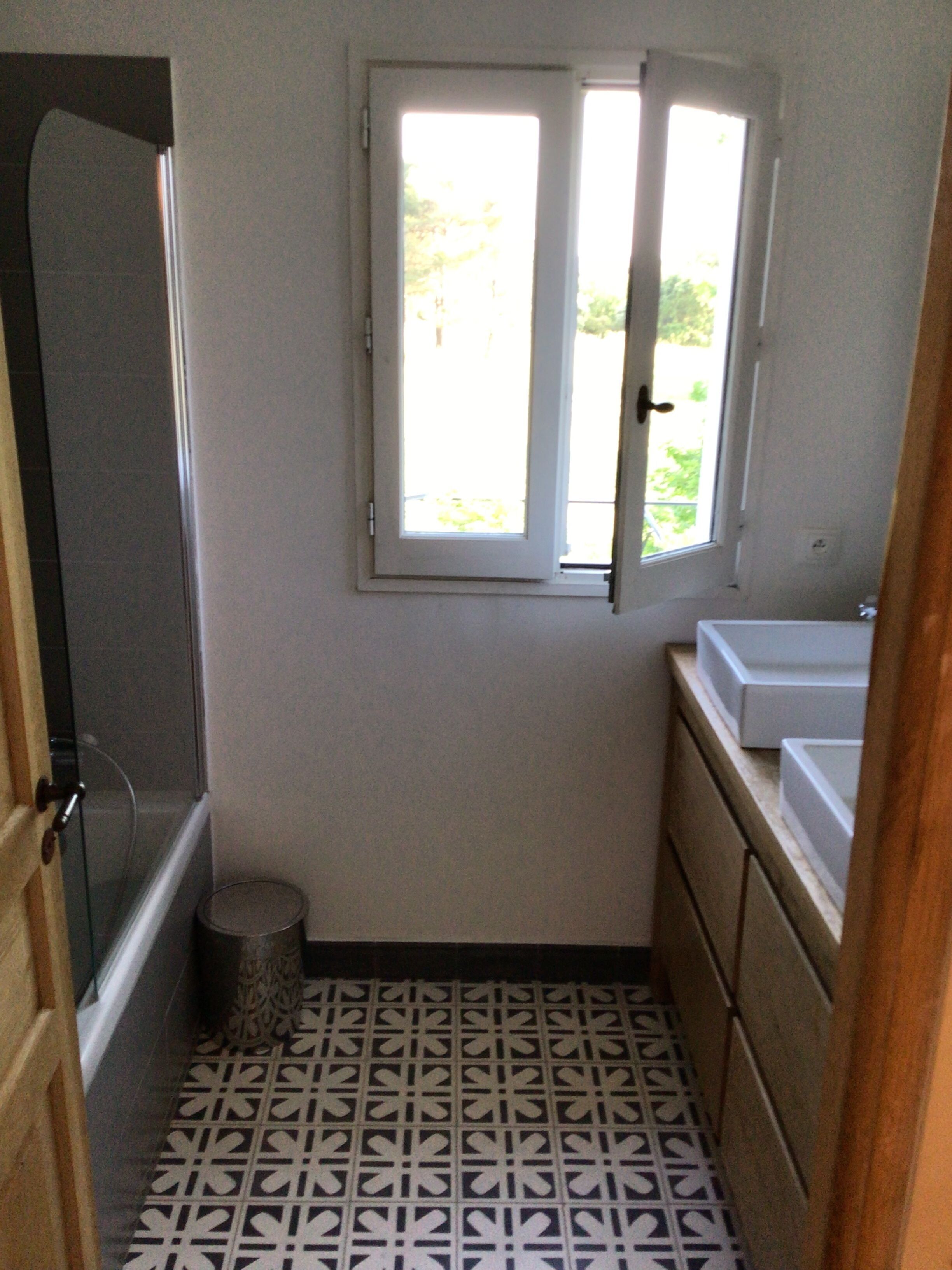 Une petite salle de bain avec une fenêtre, des toilettes et un lavabo.