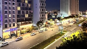 A hotel with multiple floors, a prominent sign for 'Calix Hotel', and a street with cars and greenery. - Rivera Suites (Da Nang)