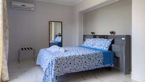 A bedroom with a bed, a bedside table, a mirror, and a wall-mounted air conditioner. - TRAMONTO, Roero Sunset (Govone)