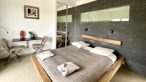 Une chambre à coucher moderne avec un grand lit, un bureau et une chaise.