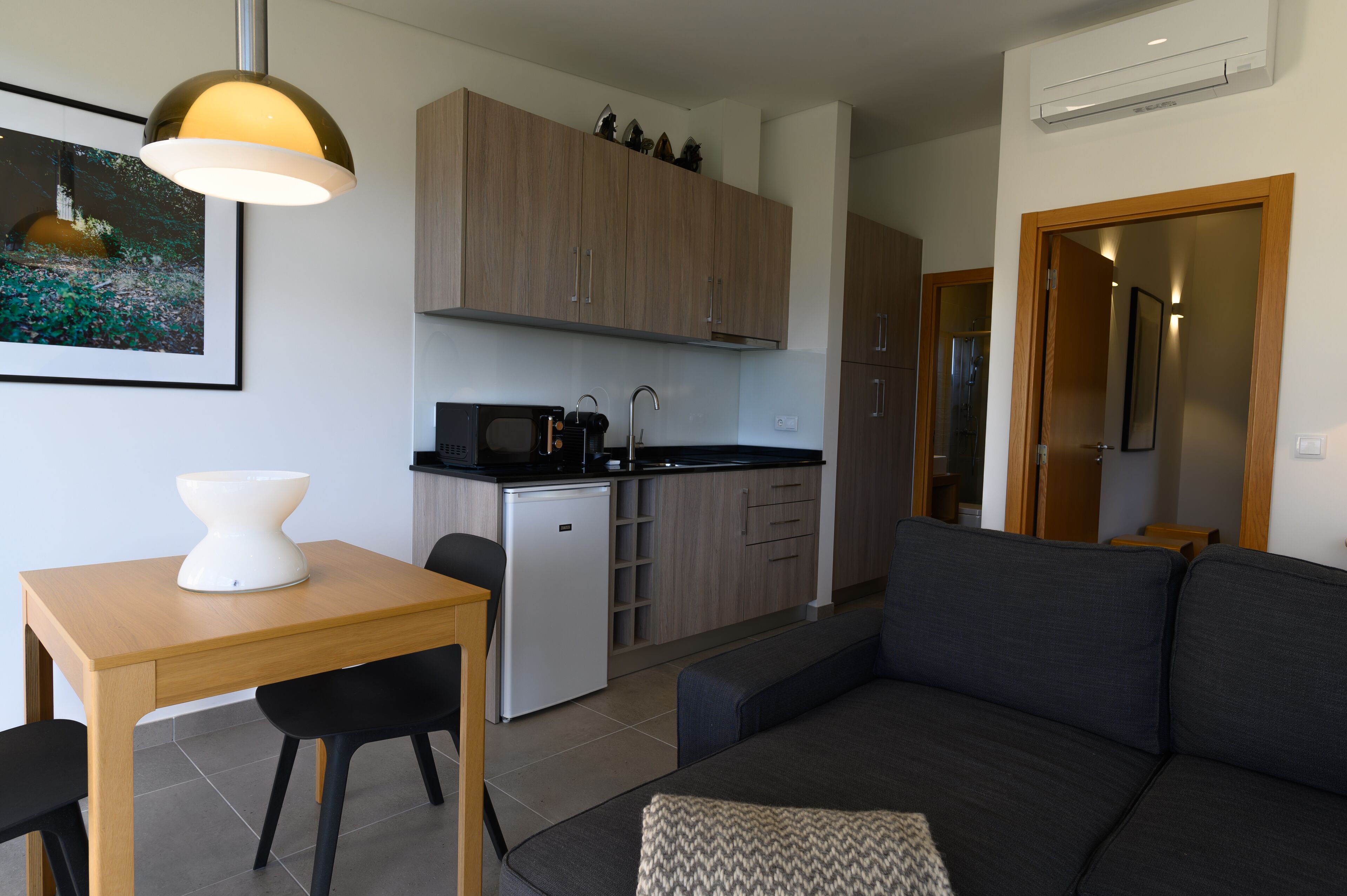 Un espacio habitable compacto con kitchenette, comedor y zona de estar.