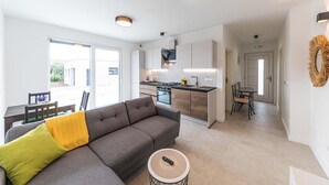 Un appartement moderne comprenant un salon, une cuisine et un coin repas.