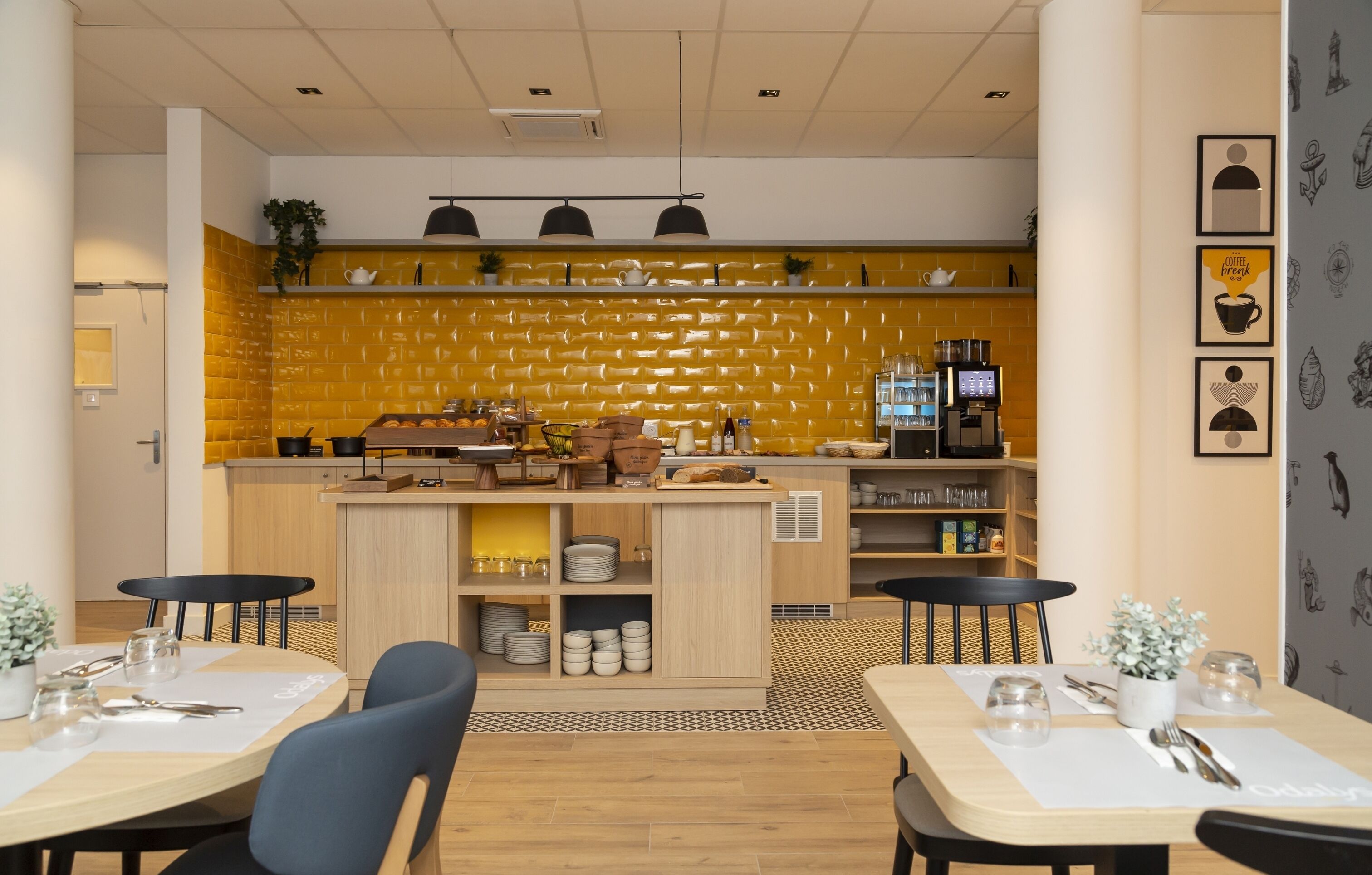 A modern cafe with a yellow brick wall, wooden tables, and black chairs.
