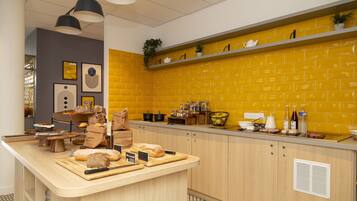 A kitchen with a wooden counter, yellow brick backsplash, and various kitchen items.