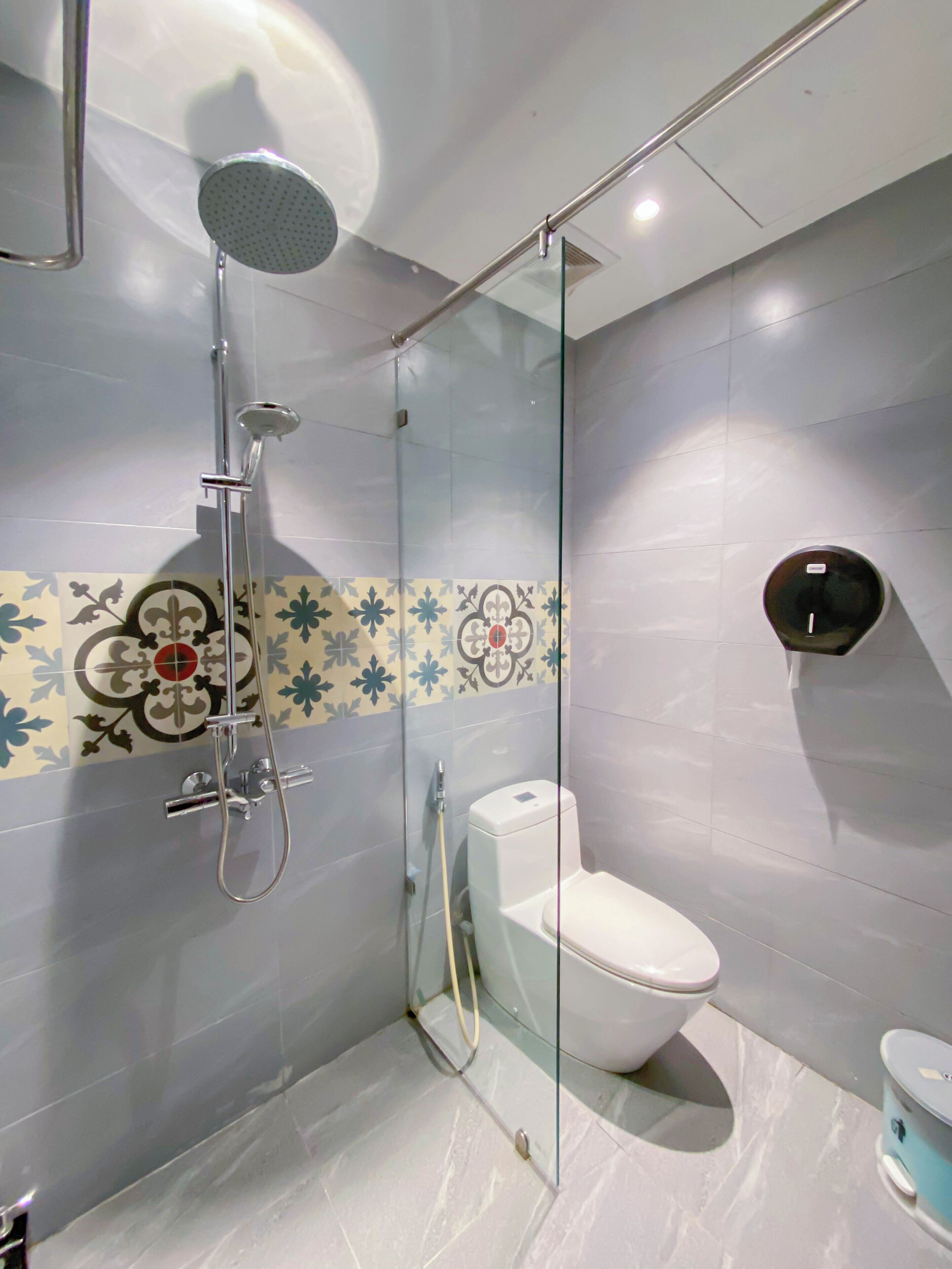 A modern bathroom with a glass-enclosed shower, a toilet, and a bidet.