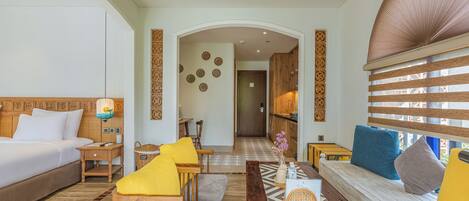 A hotel room with a bed, sofa, and a dining area.