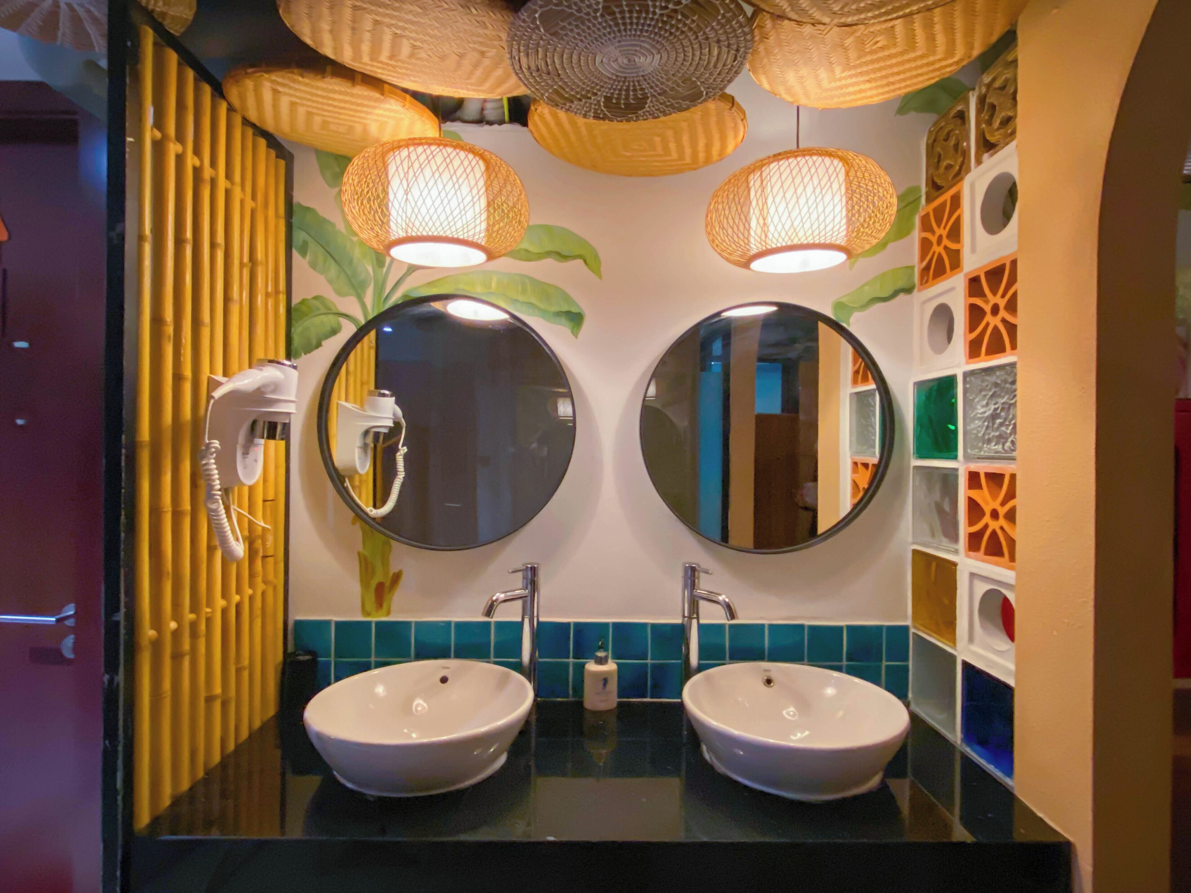 Un baño con dos lavamanos, un secador de pelo y paneles decorativos en la pared.
